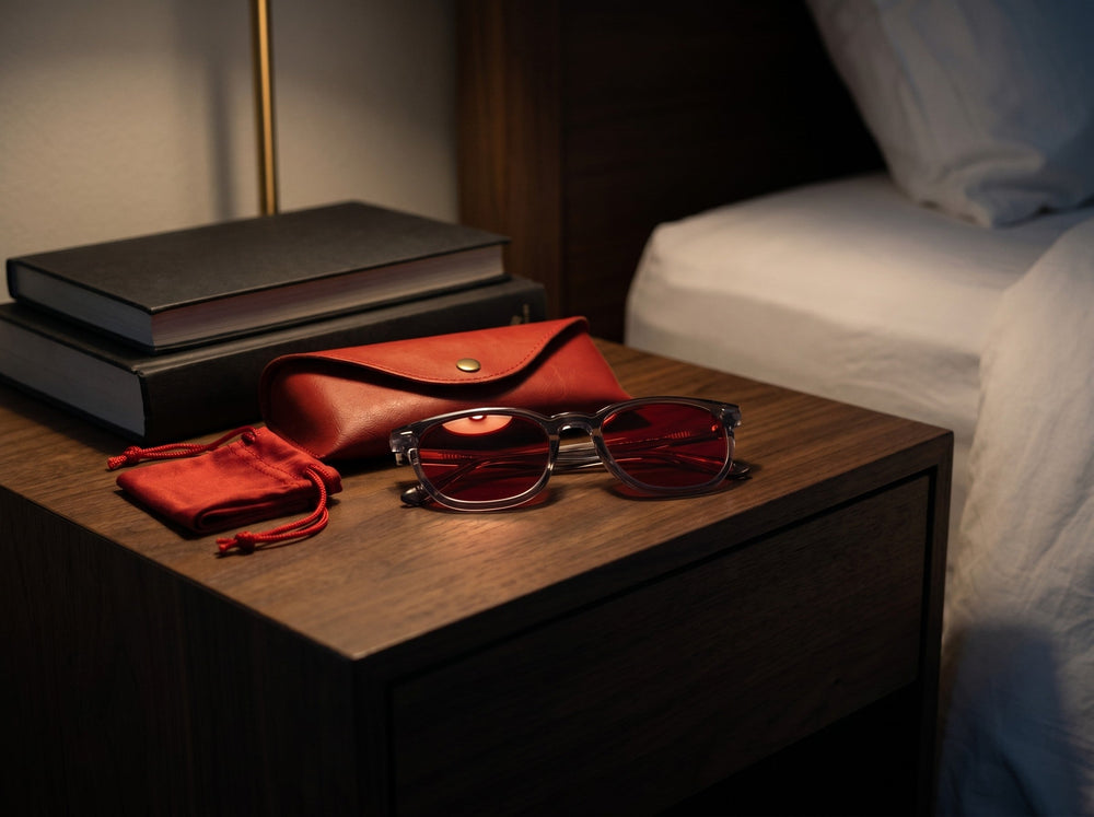Wavelength Night Lens with leather case on a bedside table at night